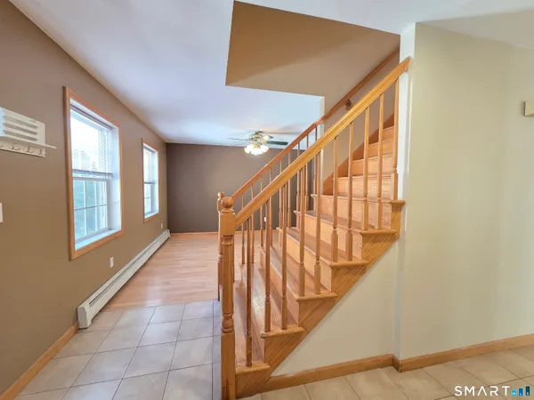 a view of a hallway with wooden floor and chandelier