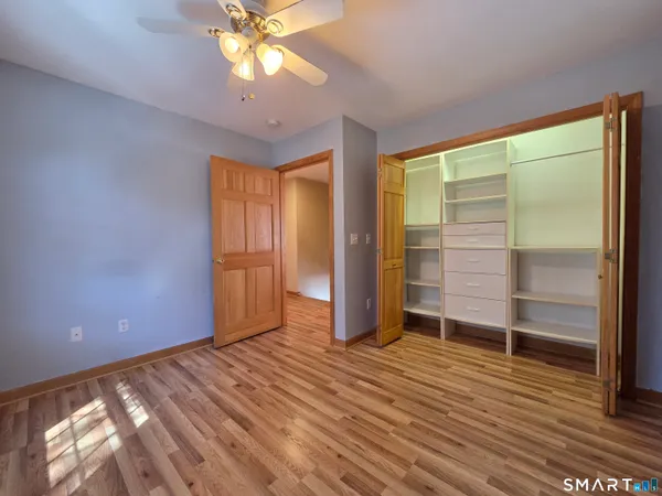a view of an empty room with a window and wooden floor