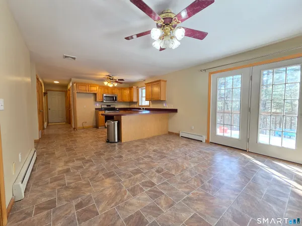 a living room with stainless steel appliances granite countertop furniture and a fireplace