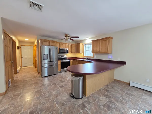 a kitchen with stainless steel appliances granite countertop a stove a sink and a refrigerator