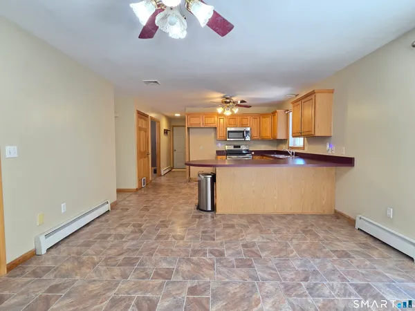 a kitchen with stainless steel appliances a sink a stove a refrigerator cabinets and a window
