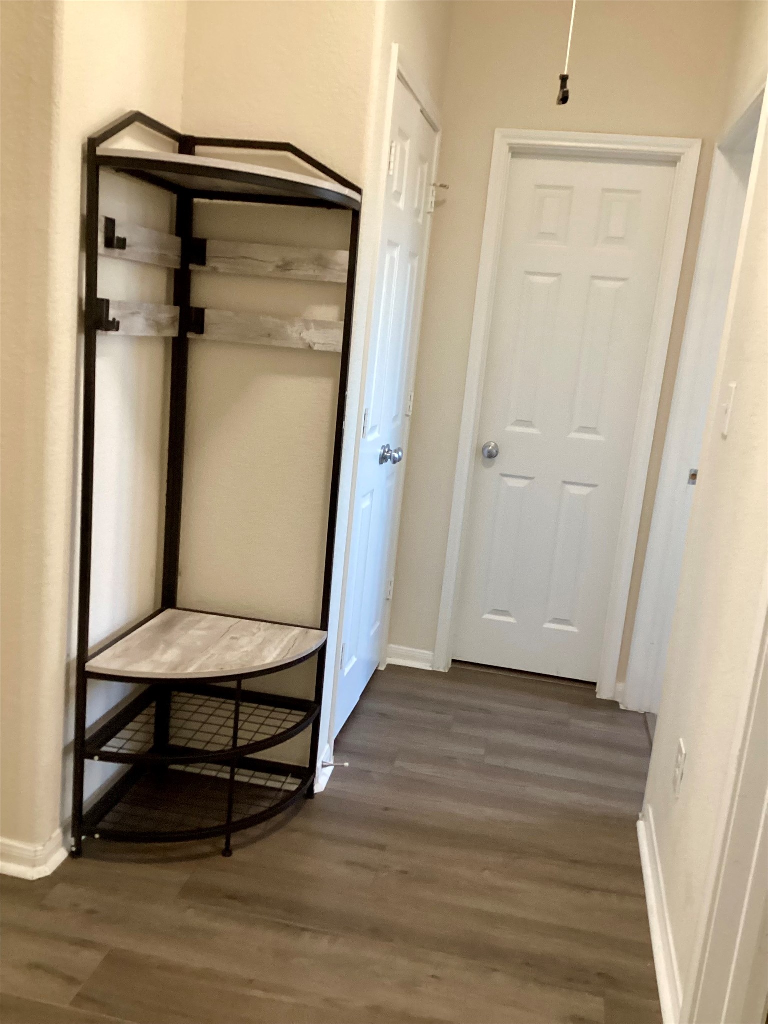 20122 Graphite Canyon Court Richmond, TX 77407 - Photo 14 of 27 This charming hallway, situated between the bedrooms, features elegant flooring and a stylish corner shelf for added functionality.