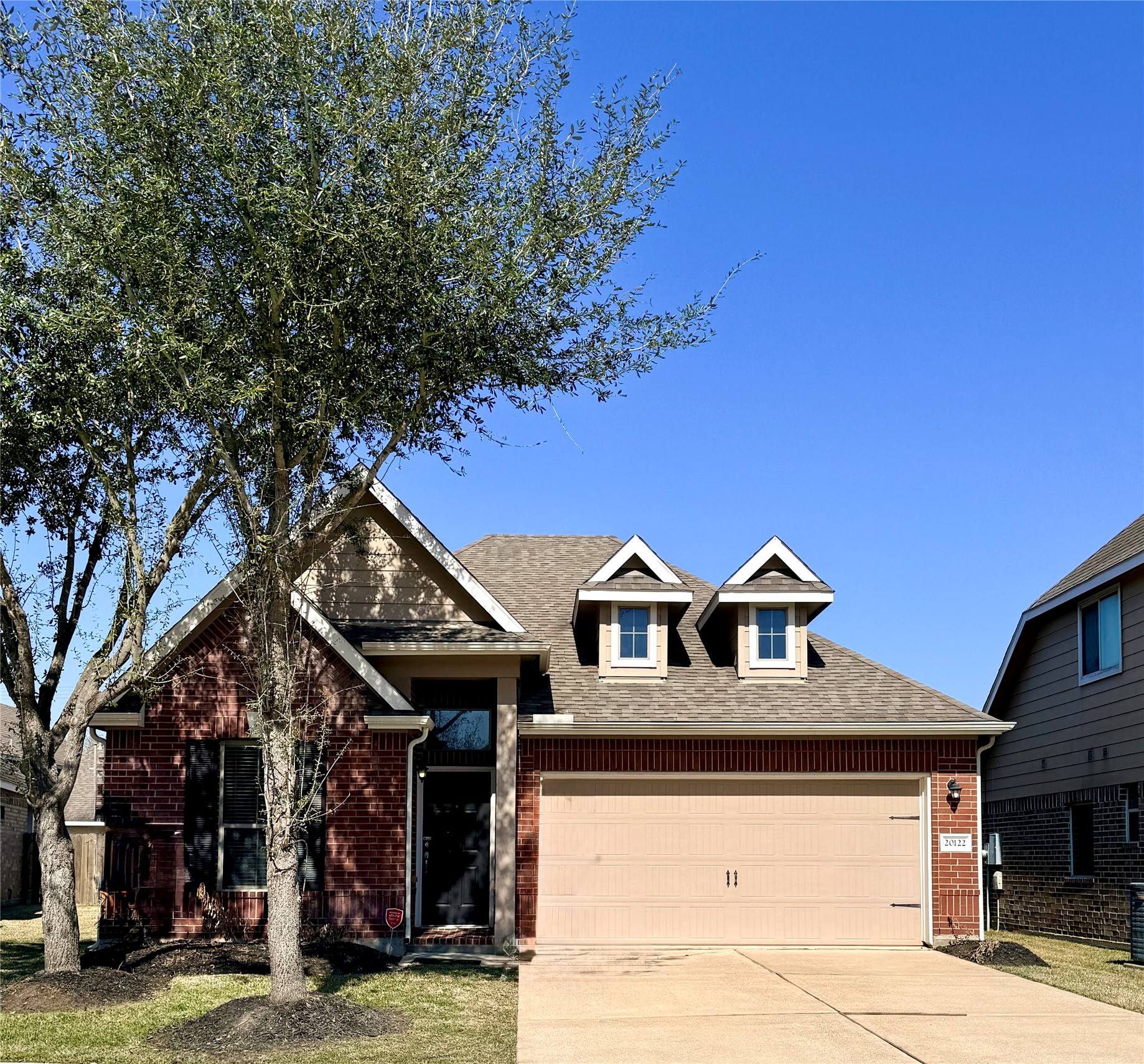 20122 Graphite Canyon Court Richmond, TX 77407 - Photo 26 of 27 Charming brick home with a two-car garage, inviting curb appeal, and character-enhancing dormer windows, nestled amid a well-maintained lawn and mature trees—perfect for those seeking a cozy suburban retreat.