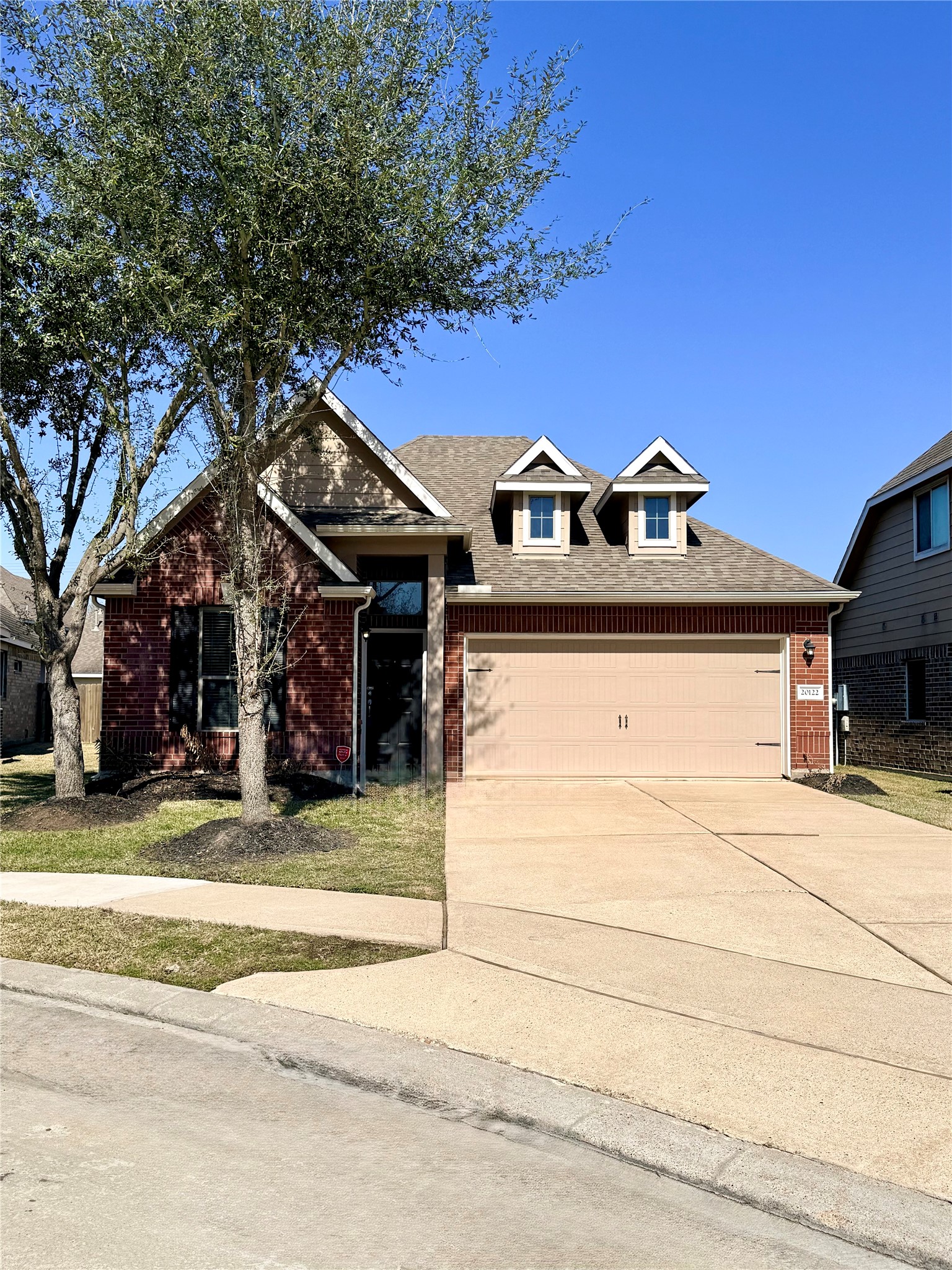 20122 Graphite Canyon Court Richmond, TX 77407 - Photo 27 of 27 This modern home features a charming gable roof with dormer windows, a spacious two-car garage, and a beautifully maintained front yard with mature trees, all set in a quiet, inviting neighborhood—offering excellent curb appeal and ample parking.