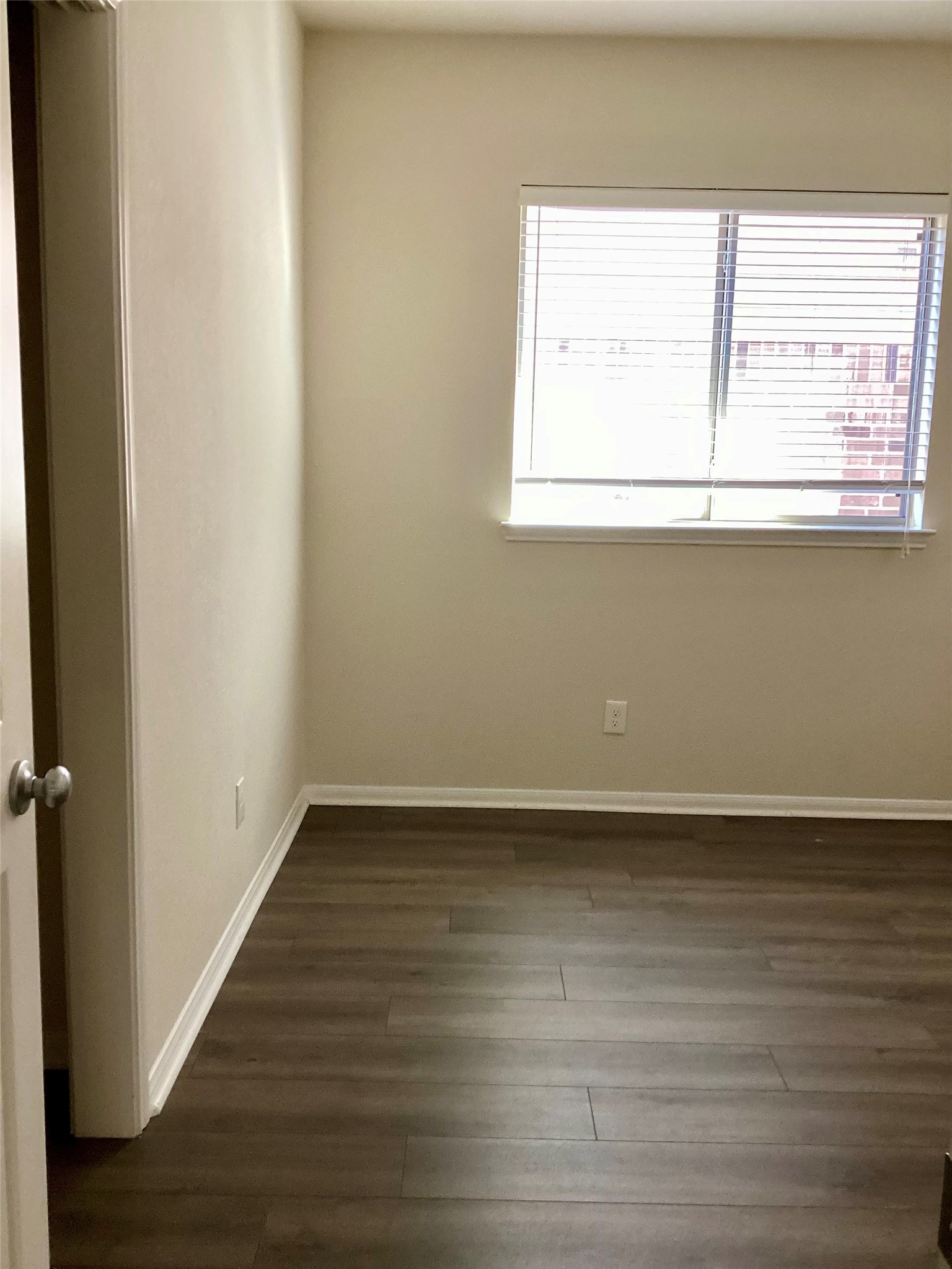 20122 Graphite Canyon Court Richmond, TX 77407 - Photo 9 of 27 Experience the cozy charm of this third bedroom with warm wood floors and abundant natural light—ideal for a serene retreat or versatile workspace.
