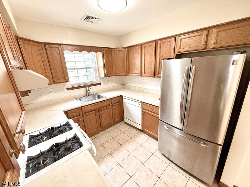 213 Palmer Street, Unit 2 Elizabeth, NJ 07202 - Photo 10 of 28 a kitchen with stainless steel appliances granite countertop a refrigerator sink and white cabinets