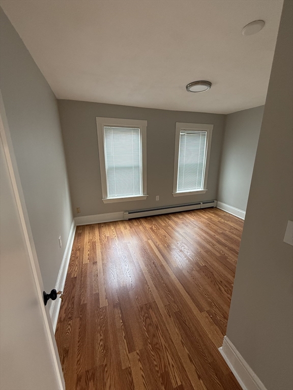 1922 Columbus Avenue, Unit 2 Boston, MA 02119 - Photo 14 of 22 wooden floor in an empty room with a window