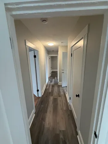 a view of a hallway with wooden floor and staircase