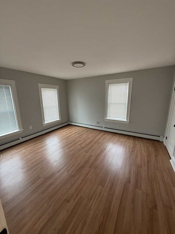 1922 Columbus Avenue, Unit 2 Boston, MA 02119 - Photo 9 of 22 an empty room with wooden floor and windows