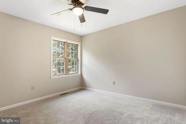 an empty room with chandelier fan