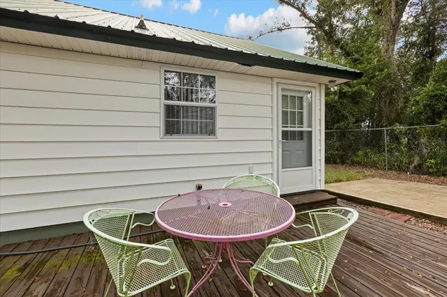 a backyard of a house with table and chairs