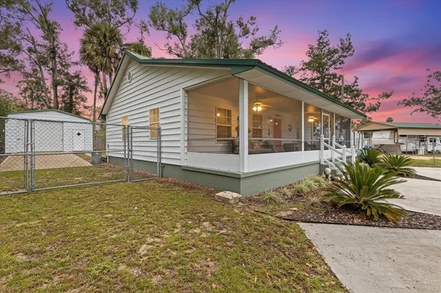 a view of a house with a small yard and potted plants