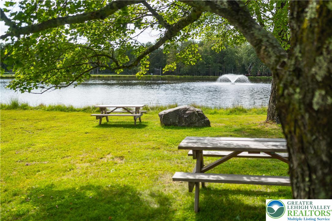 804 Evergreen Road Tobyhanna, PA 18466 - Photo 17 of 19 a view of a swimming pool with a bench and trees in the background
