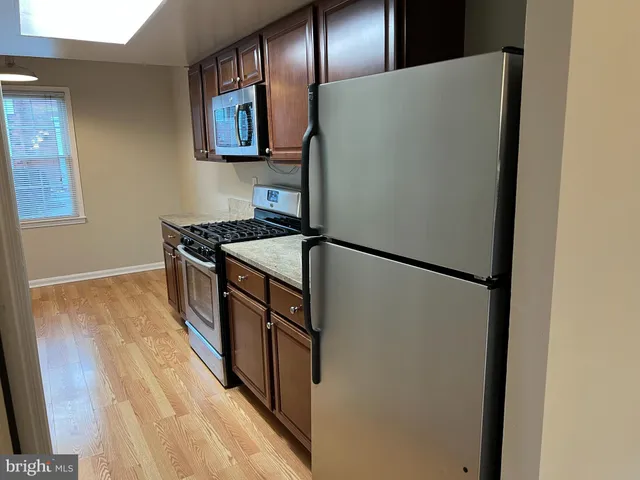 a kitchen with stainless steel appliances granite countertop a refrigerator a stove a sink and dishwasher