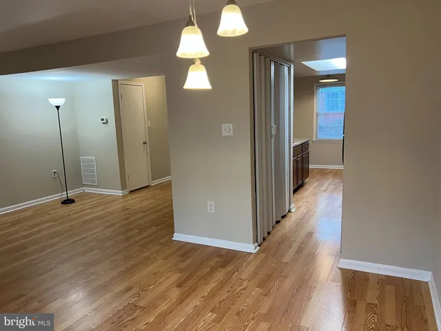 an empty room with wooden floor and mirror