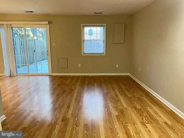 a view of a room with wooden floor and window