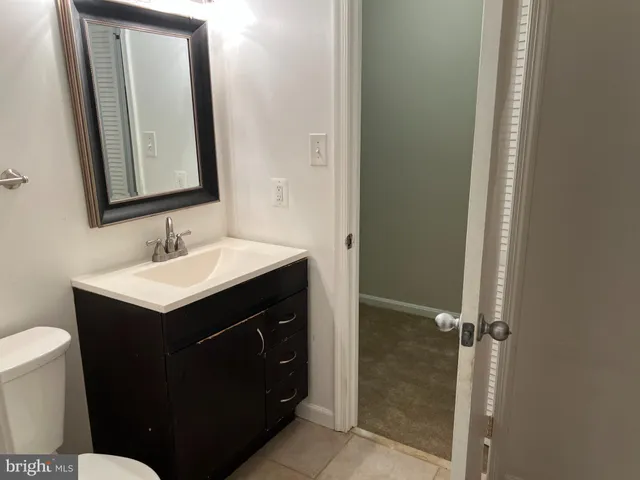 a bathroom with a sink vanity mirror and toilet