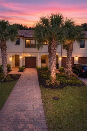 a front view of a house with a yard and potted plants
