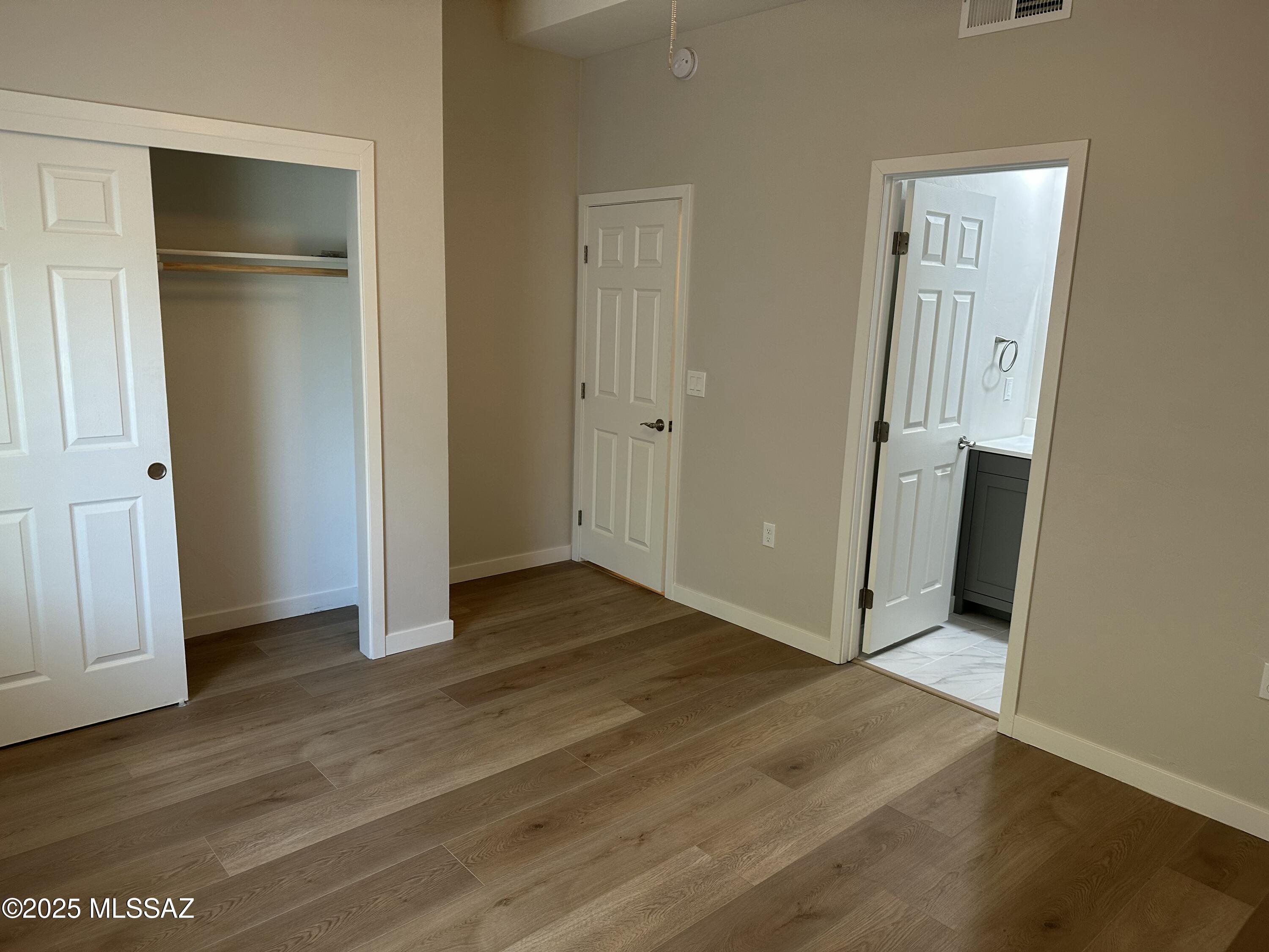 645 East Mabel Street Tucson, AZ 85705 - Photo 9 of 22 an empty room with wooden floor and closet