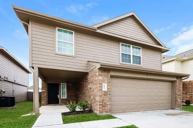 a front view of a house with a garden and plants