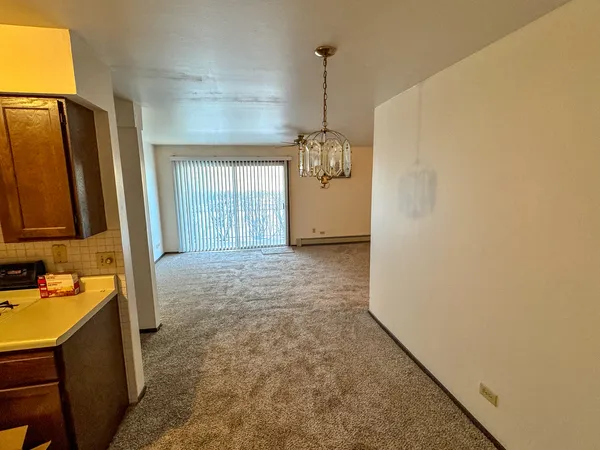 a view of a hallway to a room with windows