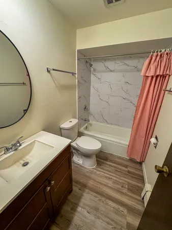 a bathroom with a sink a toilet and shower
