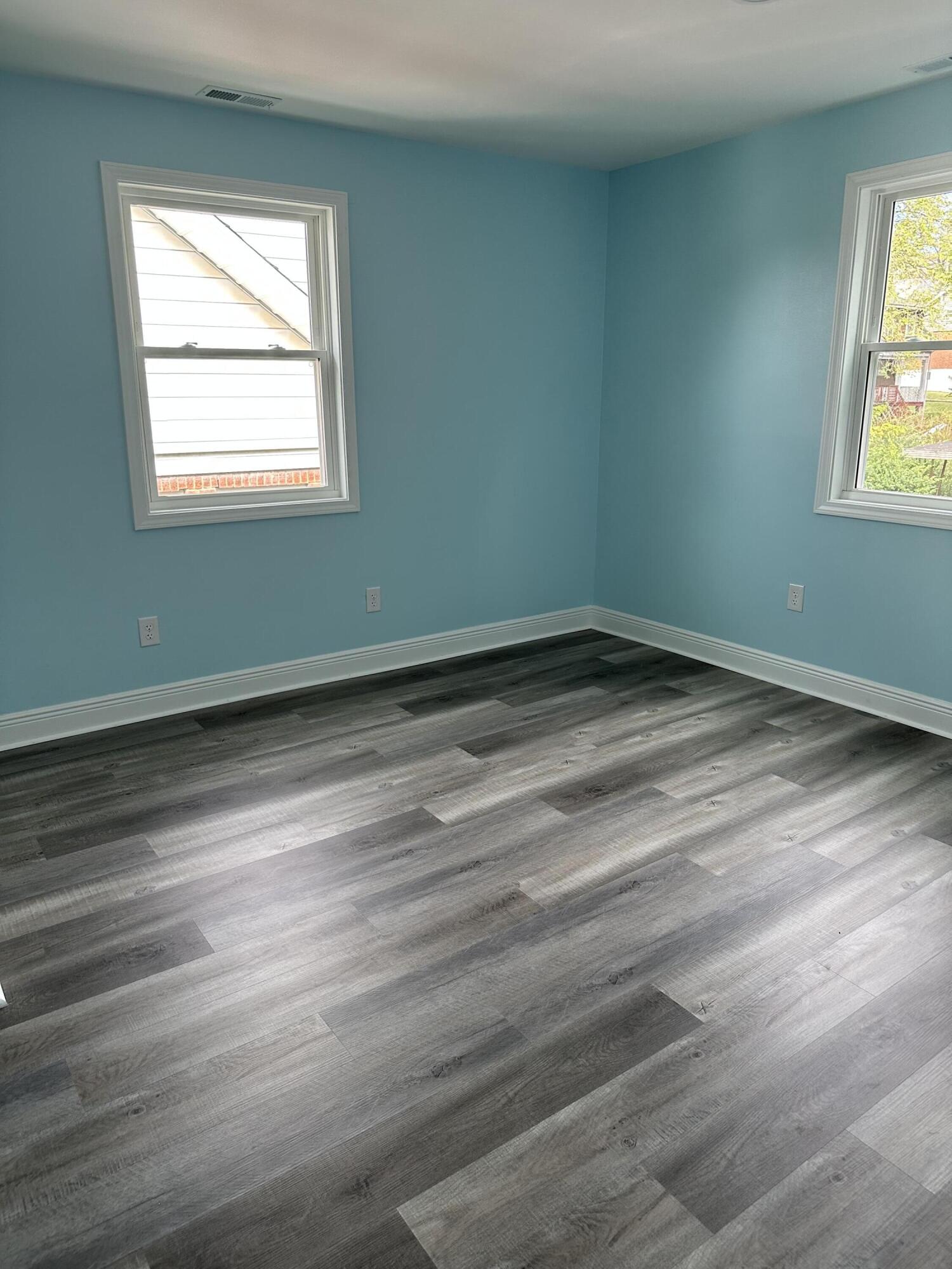707 Rutherford Avenue Northwest Roanoke, VA 24016 - Photo 19 of 22 an empty room with wooden floor and windows