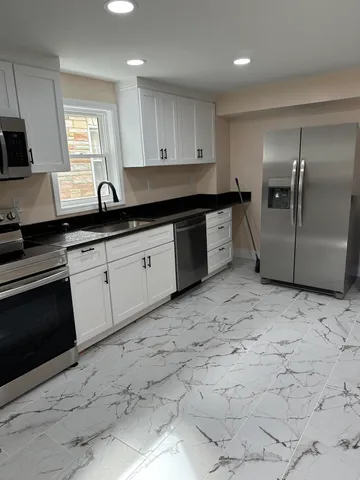 a kitchen with granite countertop a stove a sink and a microwave