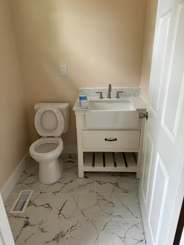a bathroom with a sink toilet and a mirror