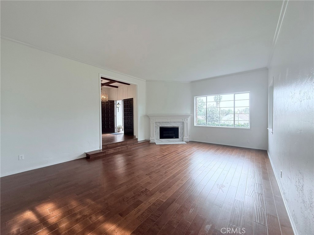 1727 Euston Road San Marino, CA 91108 - Photo 3 of 36 an empty room with wooden floor fireplace and windows