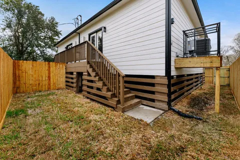 a view of a house with backyard and wooden fence