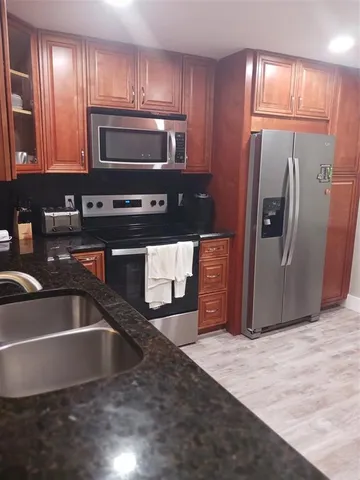 a front view of a house with a garden and car parked