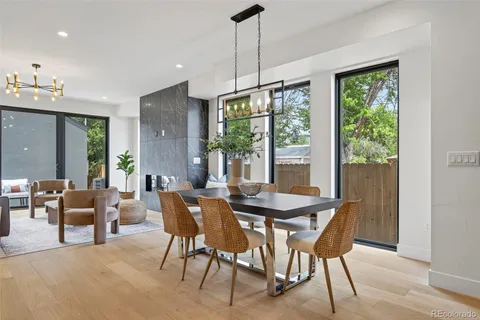 a dining room with furniture a chandelier and wooden floor