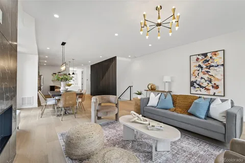 a living room with furniture a chandelier and a flat screen tv