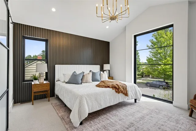 a bedroom with a large bed and a chandelier