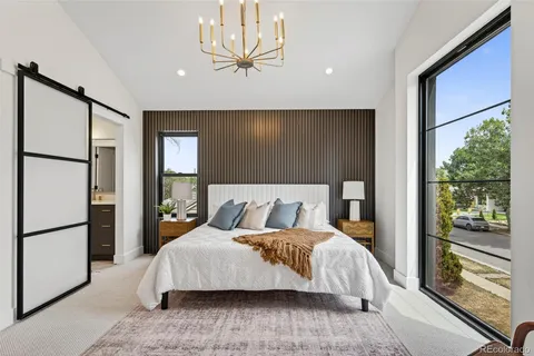 a bedroom with a large bed and a chandelier