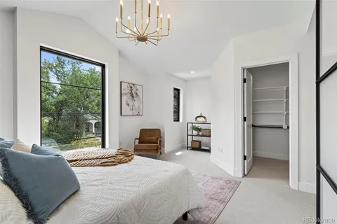 a bedroom with a large bed and a chandelier