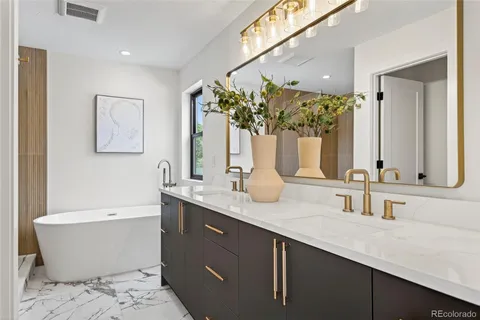 a bathroom with a double vanity sink a mirror and a bathtub