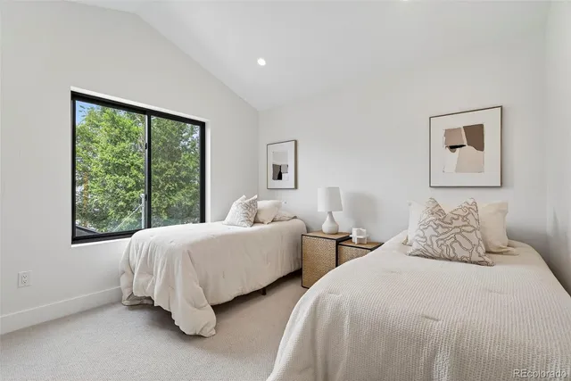 a bedroom with two beds and a large window