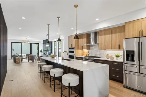 a kitchen with sink refrigerator dining table and chairs