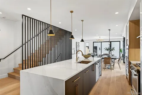 a kitchen with a table chairs stove and wooden floor