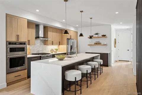 a kitchen with kitchen island a stove a table and chairs in it