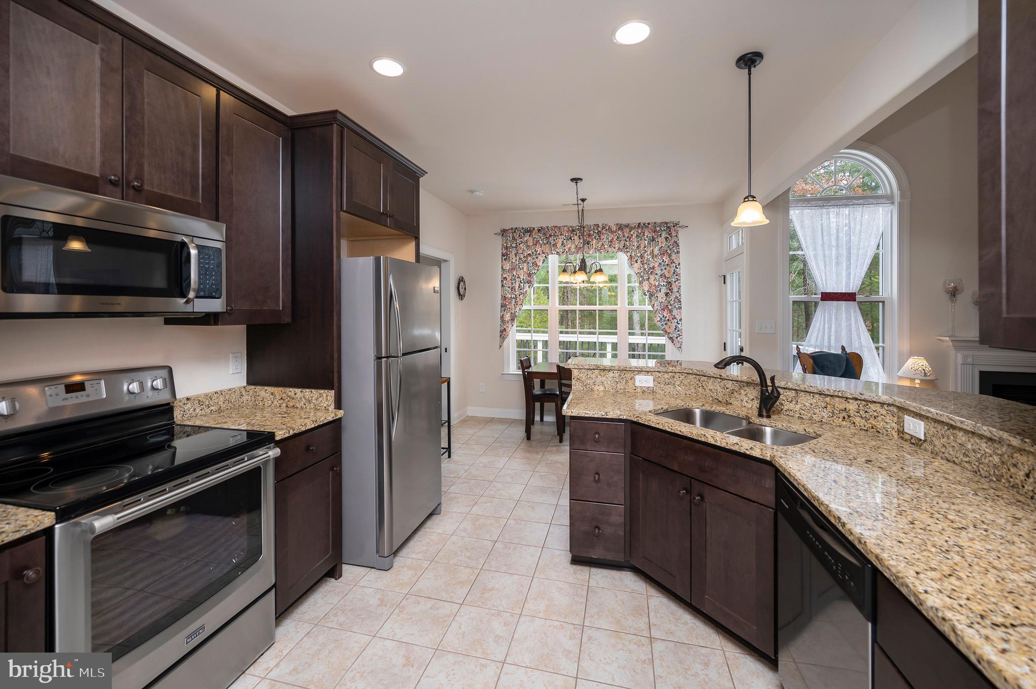 23145 Walker's Branch Road Unionville, VA 22567 - Photo 17 of 48 a kitchen with a sink a oven a refrigerator and a wooden cabinets