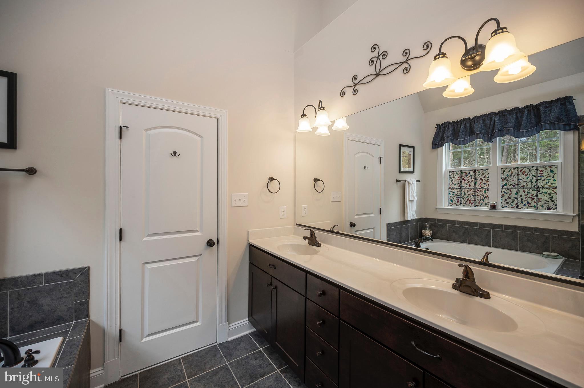 23145 Walker's Branch Road Unionville, VA 22567 - Photo 27 of 48 a bathroom with a sink double vanity granite and a mirror