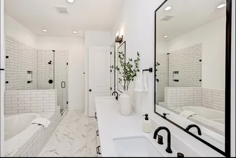 a bathroom with a tub mirror and shower