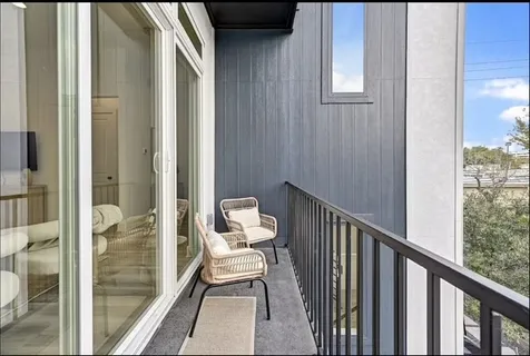 a view of a balcony and chair and floor to ceiling window