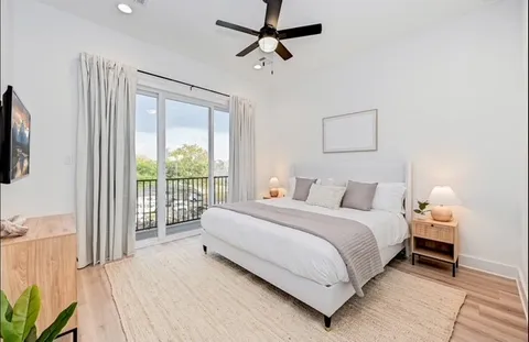 a large bedroom with a bed and a flat tv screen