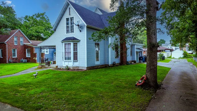 a front view of a house with a garden and yard