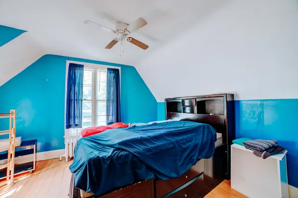 a bedroom with a bed and dresser next to a window