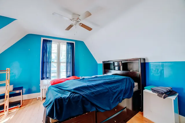 a bedroom with a bed and dresser next to a window